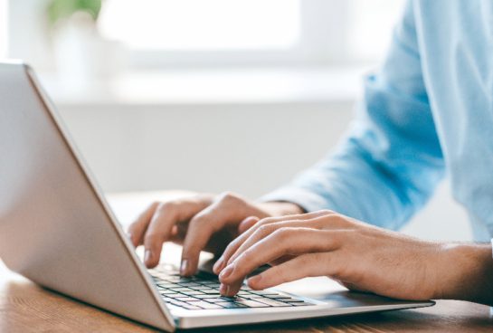 hands typing on laptop